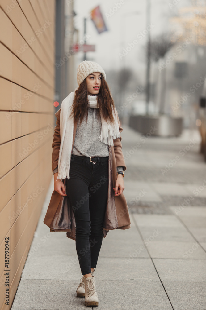 Girl walking near the wall and looking at camera. Blur yellow background Girl walking near the wall and looking at camera. Blur yellow background