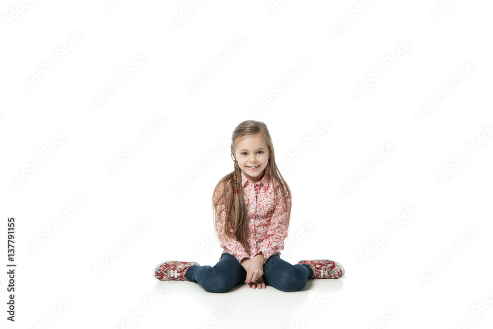 Pretty little girl sitting on the floor in jeans Pretty little girl sitting on the floor in jeans