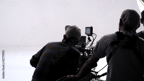 Принти на полотні Behind the scenes of TV commercial recording or shooting and movie video camera set with pan tilt head tripod rig and gimbal and film crew team is working in big studio production