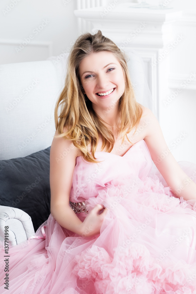 Pretty happy smiling woman in a long pale pink wedding dress