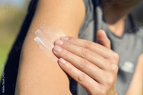 Foto man applying sunscreen to his arm