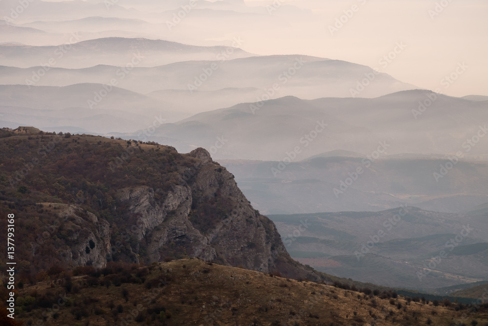 Panoramic view to the mountain ridge at the seaside of Black sea. Layer of mountains and mist at sunrise time, Crimea, Russia