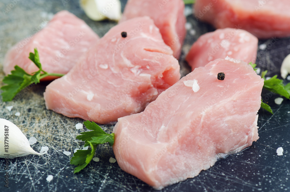 Raw Meat With Spices And Garlic Closeup On Scractched Board