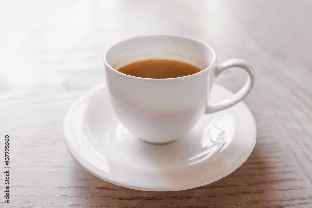 hot coffee in white cup on vintage wooden table