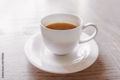hot coffee in white cup on vintage wooden table