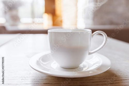 hot coffee in white cup on vintage wooden table