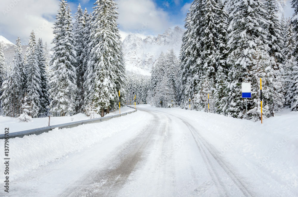 Deserted Road Through a Winter Mountain Landscape.Treacherous Driving Conditions. Deserted Road Through a Winter Mountain Landscape.Treacherous Driving Conditions.