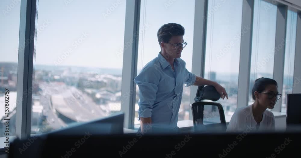 Business team working on computer together in office. Businessman and businesswoman talking about work in office. Business team working on computer together in office. Businessman and businesswoman talking about work in office.
