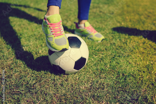 Close up view of player legs and ball on green grass outdoors background