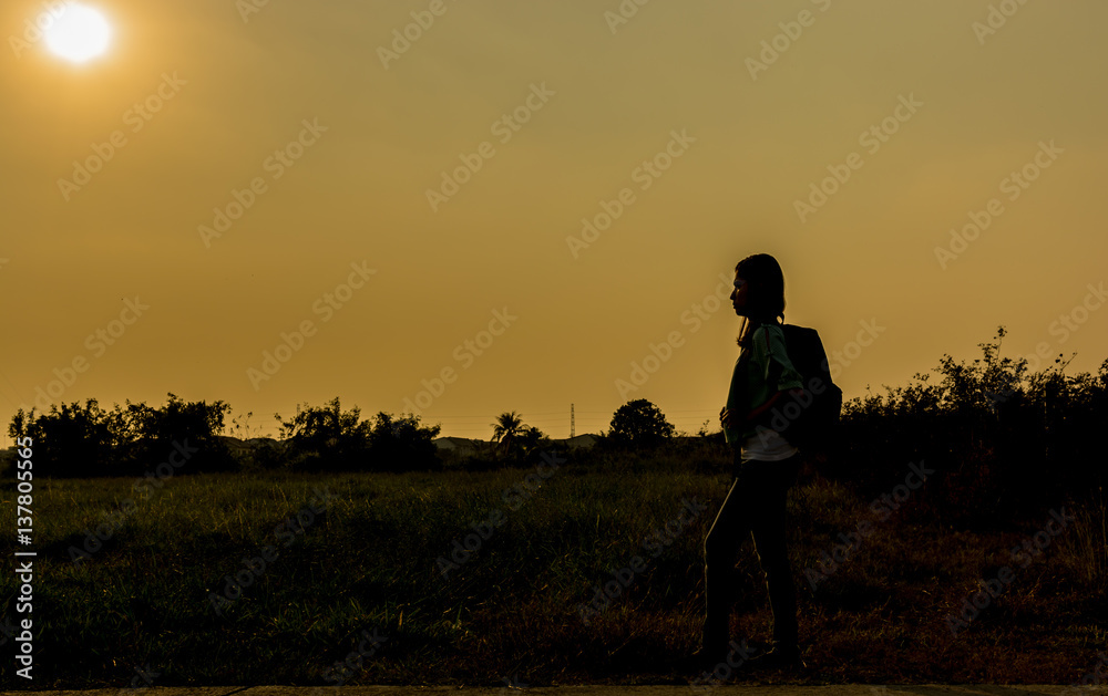 silhouette of backpack woman standing with sunset