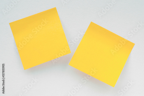 Two yellow notepaper pieces on white canvas