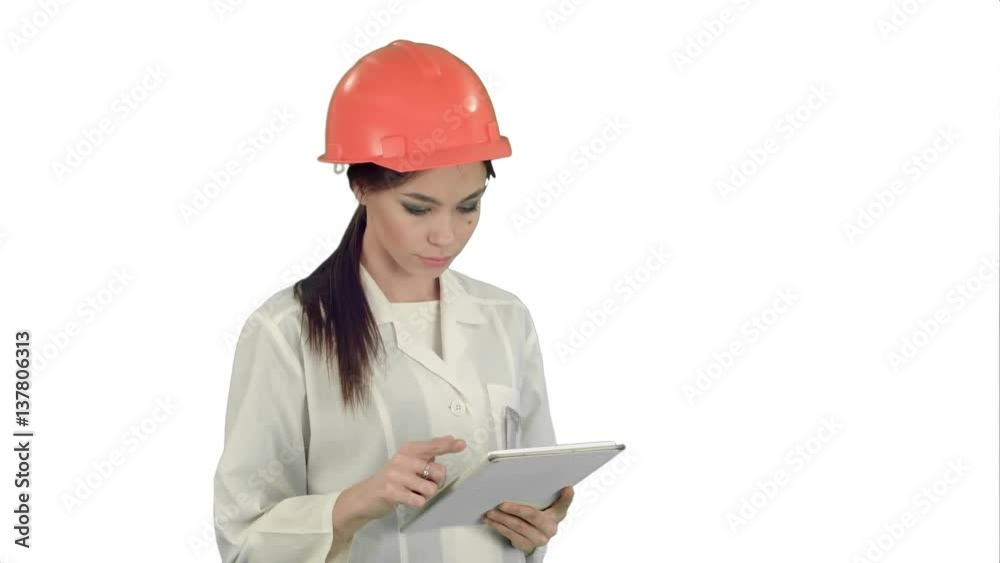Female engineer in helmet using tablet computer on white background