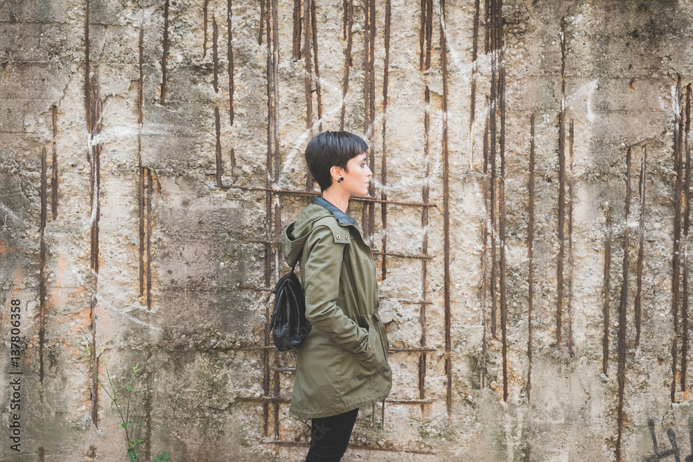 Young beautiful caucasian short hair woman posing from the side outdoor in the city Young beautiful caucasian short hair woman posing from the side outdoor in the city