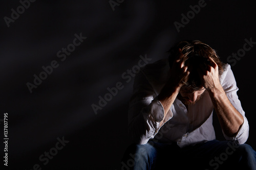 Schizophrenic man holding his head