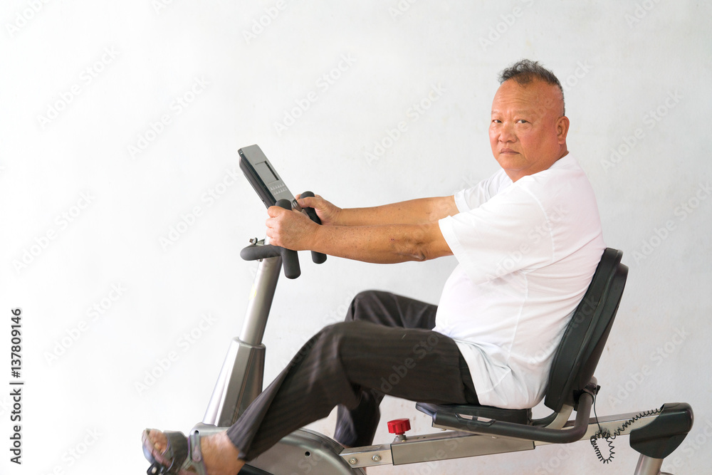 Senior riding spinning Exercise bike in a fitness class. Happy old man  using a trainer in a gym with copy space. Stock Photo | Adobe Stock
