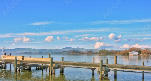 Wooden bridge on the lake Rotorua Newzeland in the bright sky.