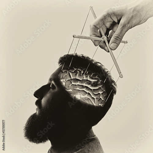 Concept manipulation of consciousness. Image of a hand, that manipulates the mind of man. Black and white.