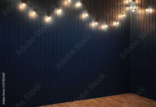 Blue wall with retro garland of light bulbs. Texture for the design