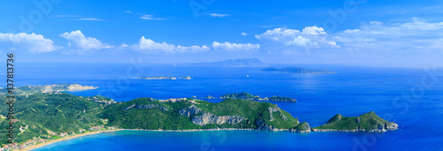 Beautiful summertime panoramic seascape. View of the cliff into the crystal clear azure sea bay and distant islands. Agios Stefanos cape. Afionas. Corfu. Greece.