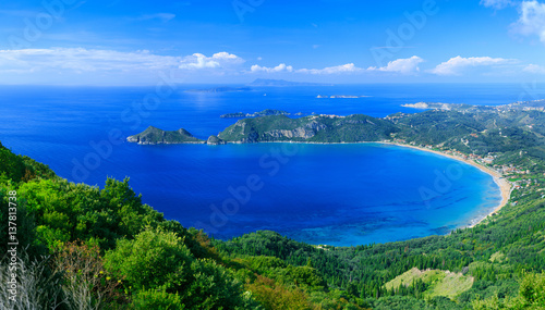 Beautiful summertime panoramic seascape. View of the cliff into the crystal clear azure sea bay and distant islands. Agios Stefanos cape. Afionas. Corfu. Greece. © Sodel Vladyslav