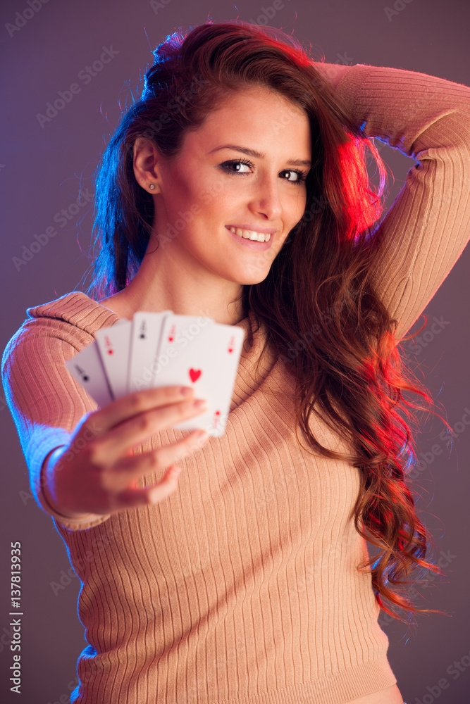 Beautiful brunette holding four aces as a sign for poker game, gambling and casino Beautiful brunette holding four aces as a sign for poker game, gambling and casino