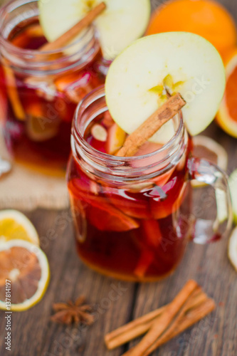 Mulled wine in glass mug with spices and citrus fruit