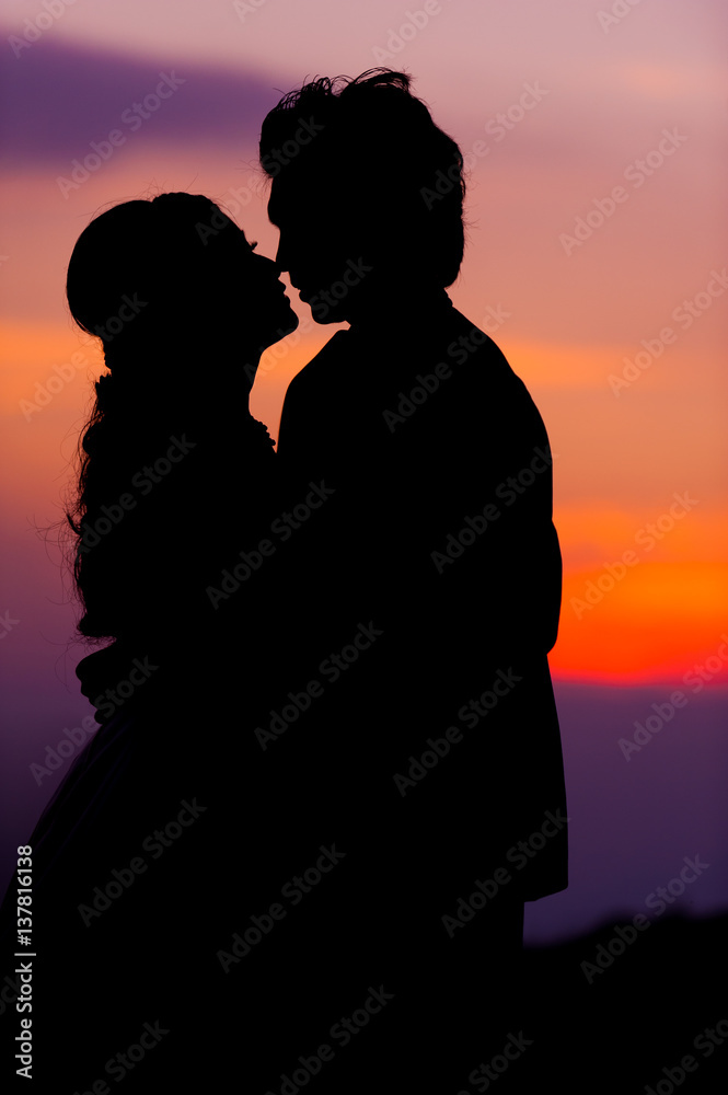 Silhouette of Embracing Asian Bride and Groom at Sunset