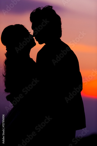 Silhouette of Embracing Asian Bride and Groom at Sunset