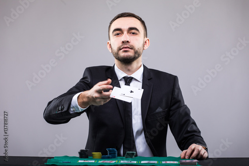 Poker player in suit throwing two ace cards. photo