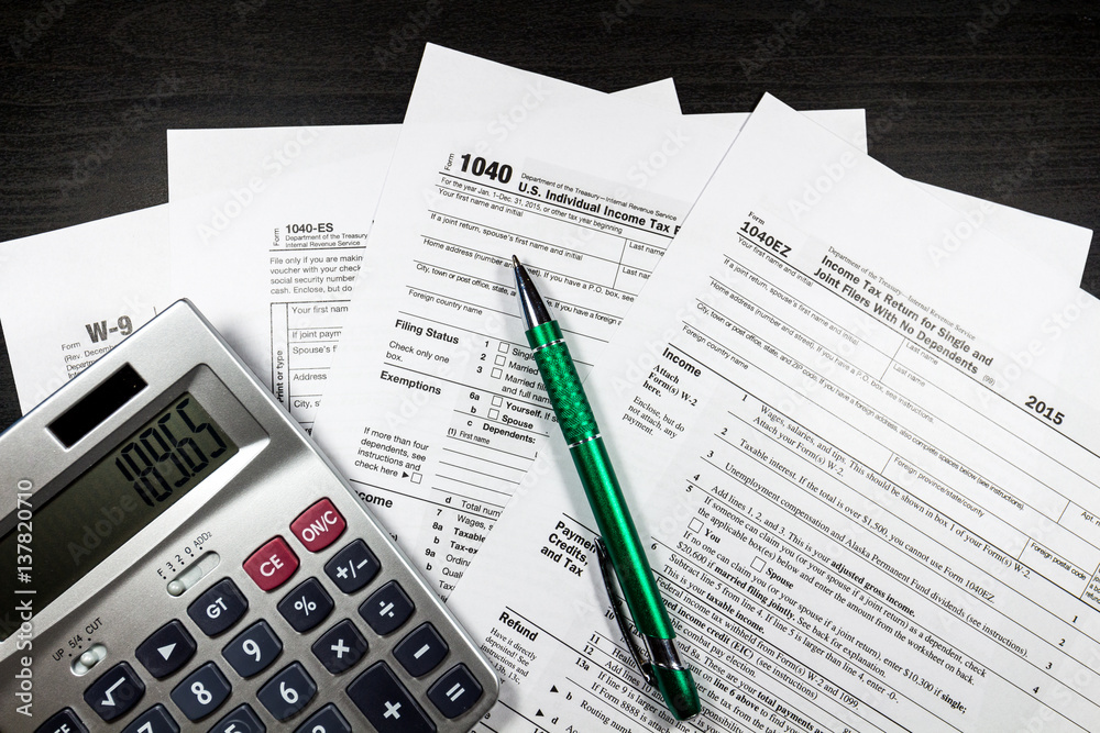1040 and W-9 Forms with pen and calculator 1040 and W-9 Forms with pen and calculator