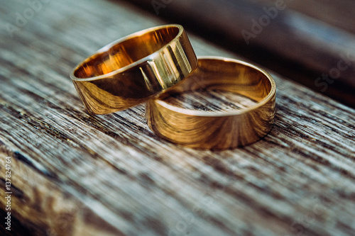 macro of wedding rings on dark wood in day light