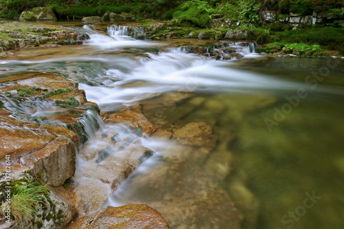 Fototapeta Naklejka Na Ścianę i Meble -  Waterfall and stream in the forest mountain valley