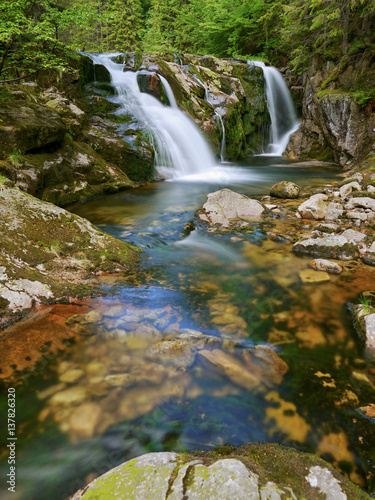 Waterfall and stream in the forest mountain valley