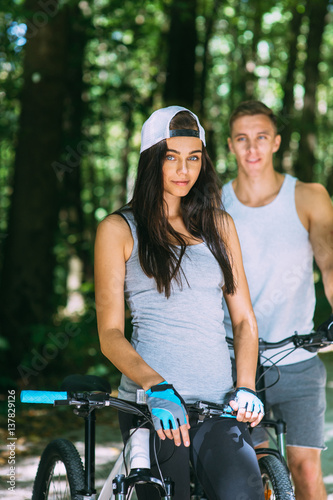 Young Couple Riding Bike In Park