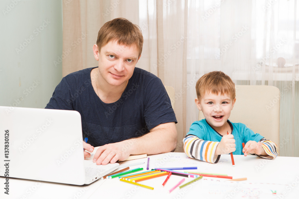 Little boy drawing while his father is working on a laptop and speaks by phone in the home. father is a freelancer.
Little boy drawing while his father is working on a laptop and speaks by phone in the home. father is a freelancer.