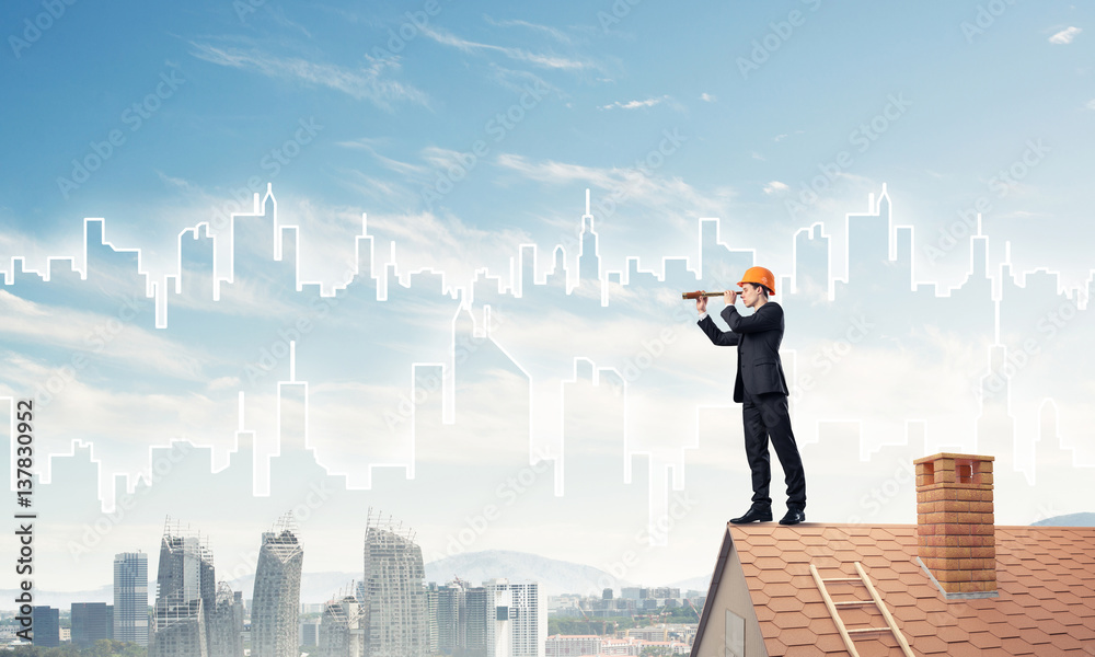 Engineer man standing on roof and looking in spyglass. Mixed med Engineer man standing on roof and looking in spyglass. Mixed med