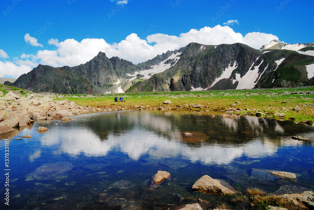  Mountain Lake with clean water in the Caucasus summer. Blue sky with white clouds.
