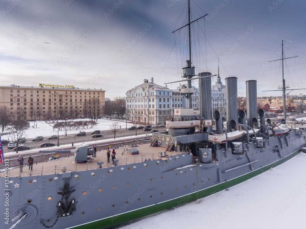 Russia, Saint-Petersburg, 10 February 2017: Aero shootings of a winter panorama monument of October revolution cruiser the Aurora at sunset, the Nakhimov Military Naval School, frozen river Neva