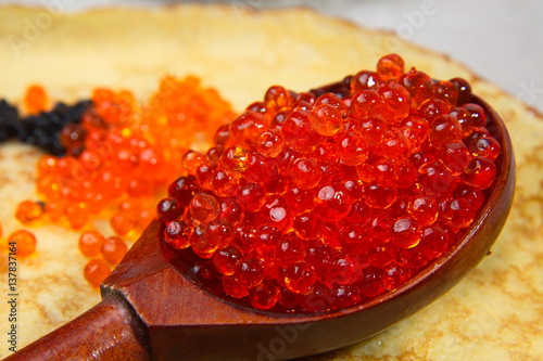 Pancakes with red caviar on a table. Shrovetide.