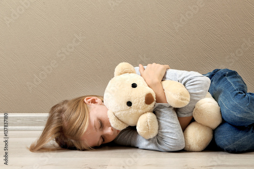 Upset girl with teddy bear ...