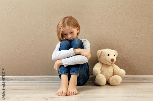Upset girl with teddy bear ...