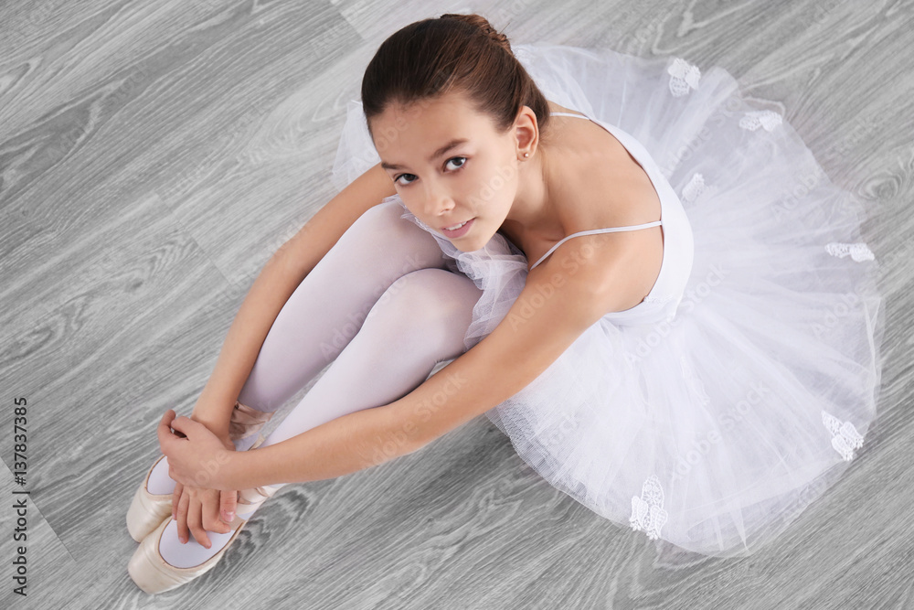 Foto Stock Little ballerina sitting on floor, top view | Adobe Stock