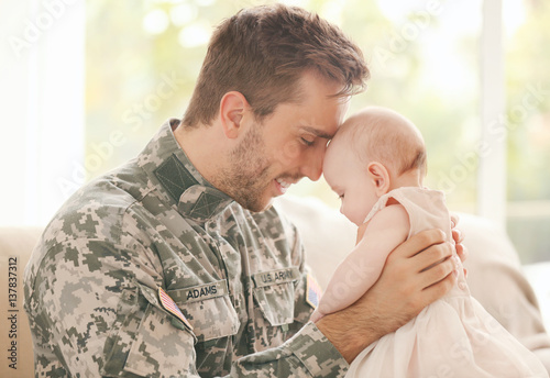 Military father holding his...