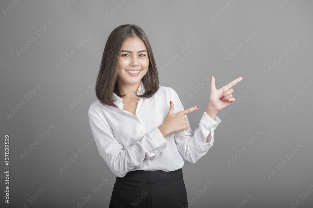 Beautiful Business Woman presenting something on grey background Beautiful Business Woman presenting something on grey background