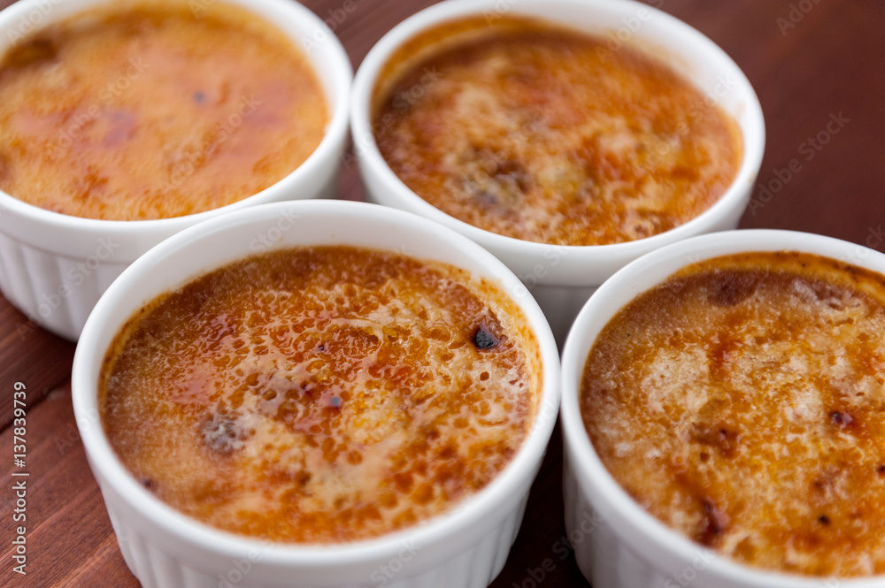Creme brulee in a white bowl with sugar crust. Studio photography. country style. Creme brulee in a white bowl with sugar crust. Studio photography. country style.