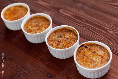 Creme brulee in a white bowl with sugar crust. Studio photography. country style.