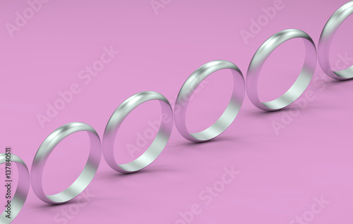 3d render of silver rings in a row on a pink background