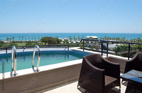 View of the small pool and the beach from the balcony of  Turkish hotel.