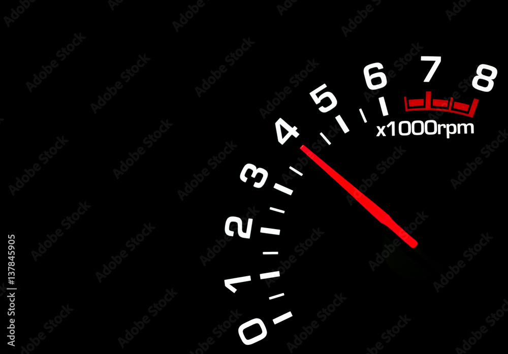 Close up shot of a car speedometer tachometer on black background
