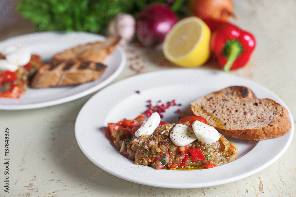 Italian appetizer of eggplant with mozzarella cheese. On vegetables background Italian appetizer of eggplant with mozzarella cheese. On vegetables background